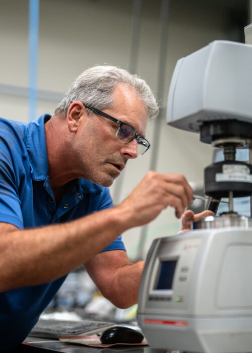 A Bluegrass employee closely examines construction materials in the lab in Kentuckiana
